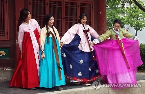 Foreign travelers show off their hanbok during their visit to a traditional village in Seoul on July 3, 2016. 