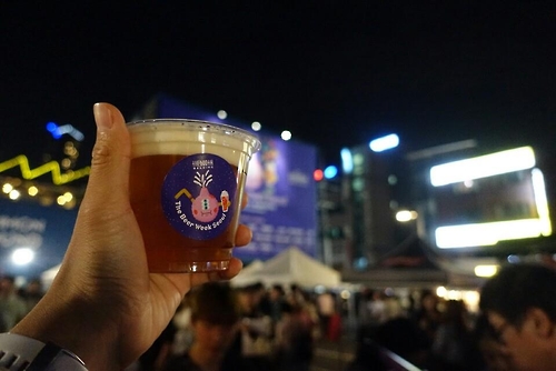 A participant in the Beer Week Seoul festival grips a cup of craft beer on Sept. 21, 2016. 