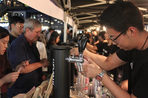 Dan Brousseau from Chicago (L) is waiting for a cup of craft beer, joining the Beer Week Seoul event on Sept. 21, 2016.