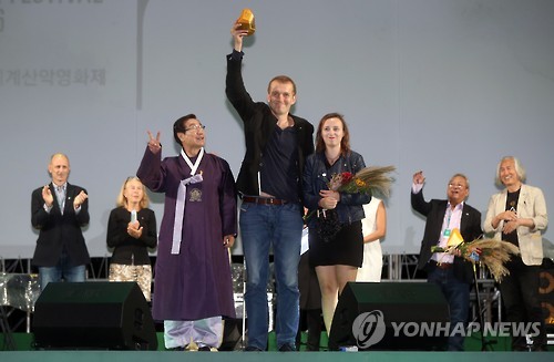 Filmmaker Pawel Wysoczansk (C) celebrates after his film, "Jurek," won the top prize of 20 million won (about US$18,000) in the international competition during the closing ceremony of the Ulju Mountain Film Festival in the southeastern county of Ulju on Oct. 4, 2016. 
