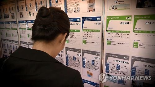 A female job seeker looks at job advertisements at a job fair.