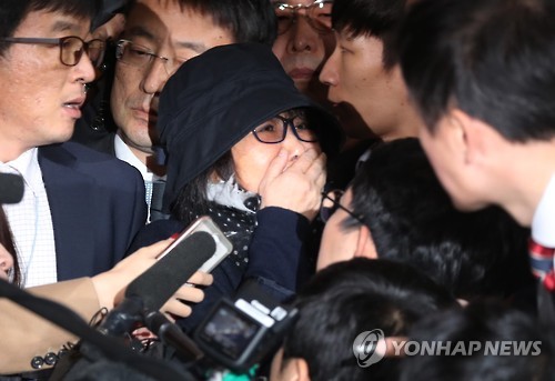 Choi Soon-sil, the woman at the center of South Korea's political scandal, is surrounded by reporters as she enters the Seoul Central District Prosecutors' Office for questioning on Oct. 31, 2016.