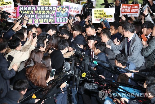 Choi Soon-sil, who is suspected of having meddled in state affairs and peddled influence on various state projects by exploiting her decades-long friendship with President Park Geun-hye, passes through a huge group of reporters to enter the Seoul Central District Prosecutors' Office in Seoul for questioning on Oct. 31, 2016.
