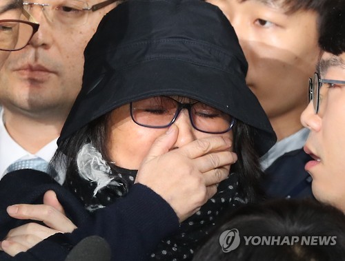 Choi Soon-sil, who is suspected of having meddled in state affairs and peddled influence on various state projects by exploiting her decades-long friendship with President Park Geun-hye, covers her face with her hand while entering the Seoul Central District Prosecution Office in Seoul for questioning on Oct. 31, 2016. 