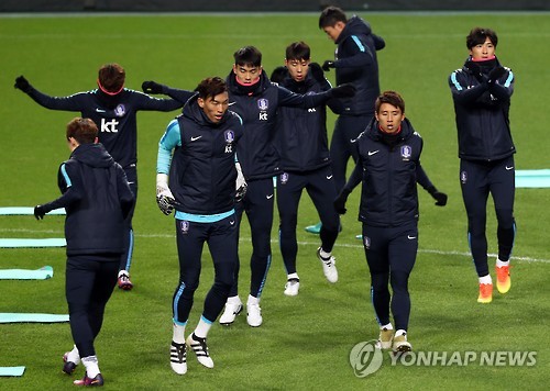 South Korean national football team players conduct warm up exercises during their training session at Seoul World Cup Stadium on Nov. 8, 2016.