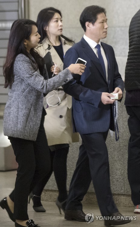 Ahn Bong-geun (R), a former presidential secretary for public relations, is chased by reporters as he appears at the Seoul Central District Prosecutors' Office on Nov. 14, 2016, to undergo questioning over the latest influence-peddling scandal centered on President Park Geun-hye's confidante. 