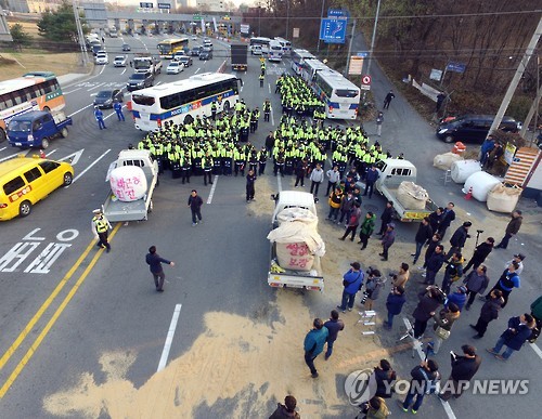 The members of the Korean Peasants League, or Jeonnong, confront police in Pyeongtaek, some 70 kilometers south of Seoul, on Nov. 25, 2016, as the law enforcement authorities banned them from entering the capital city. The farmers' association planned to hold a rally in central Seoul later in the day.