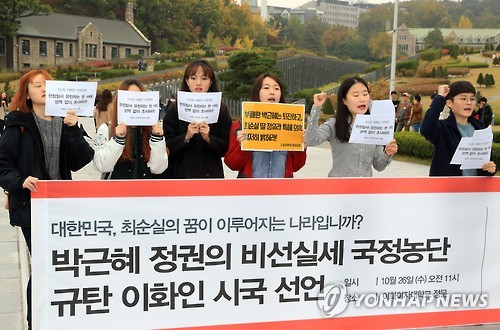 A group of students at Ewha Womans University in Seoul calls for a thorough investigation into allegations Choi Soon-sil, a close friend of President Park Geun-hye, meddled in state affairs using her ties to the president, at the school's front gate on Oct. 26, 2016. 