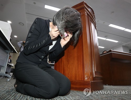 In this file photo taken on Sept. 27, 2016, Choi Eun-young, former chairwoman of Hanjin Shipping, sobs on her knees during a parliamentary audit at the government complex in Sejong, central South Korea. Choi, who served as the shipper's head from 2008 and 2014, offered an apology over the fall of the country's No. 1 container shipping line currently under court receivership.