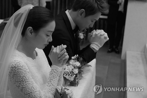 In this photo provided by the Rain Company, singer-actor Rain and actress Kim Tae-hee pray during their wedding at Gahoe-dong Church in central Seoul on Jan. 19, 2017.