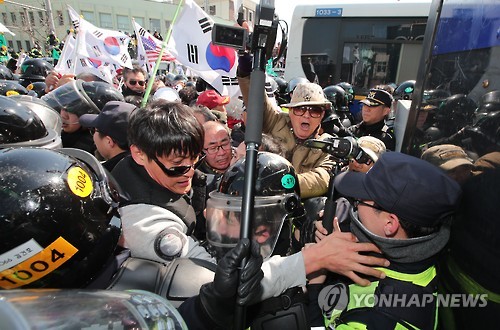 Protesters from conservative civic bodies scuffle with police at an intersection leading to the Constitutional Court in Seoul on March 10, 2017, after the court upheld the impeachment of the president. The ruling, which was announced by the court's acting chief and televised live, made Park the nation's first democratically elected leader to be ousted.
