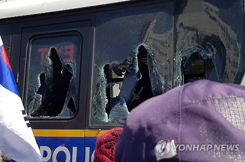 A police bus near the Constitutional Court in central Seoul is damaged on March 10, 2017, as Park Geun-hye supporters clash with police on their way to the court after it ruled to remove Park from her post as the country's president.