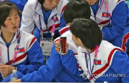 A North Korean women's hockey player holds a can of Coca-Cola while chatting with her teammate during the game between South Korea and Slovenia at the International Ice Hockey Federation Women's World Championship Division II Group A at Kwandong Hockey Centre in Gangneung, Gangwon Province, on April 2, 2017. (Yonhap)