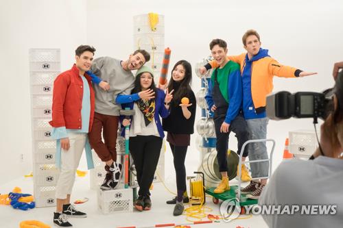 This photo provided by IMMABB shows members of EXP Edition posing for a photo with team producer Karin Kuroda and IMMABB chief Kim Bora (3rd, 4th from L). (Yonhap)