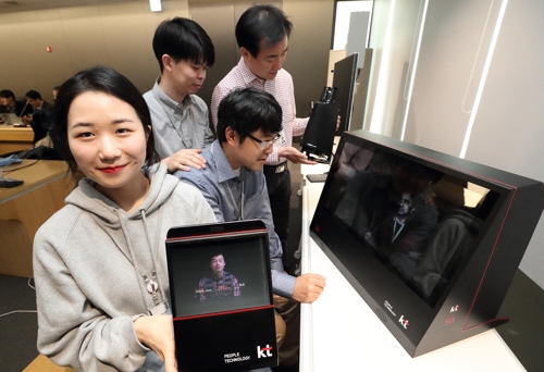 Employees of KT Corp. demonstrate a hologram call powered by the fifth-generation network technology in Seoul in this photo released by the mobile carrier on April 3, 2017. (Yonhap)