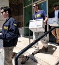 Federal agents carried out boxes of evidence after a raid this month on a California business accused of helping wealthy Chinese investors fraudulently obtain green cards. Credit Richard Vogel/Associated Press