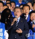 This photo, taken on May 8, 2017, shows Moon Jae-in (C), the then-presidential candidate of the liberal Democratic Party, and his party colleagues singing the national anthem during his election campaign in Seoul. (Yonhap)