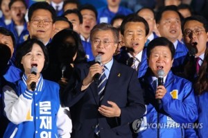 This photo, taken on May 8, 2017, shows Moon Jae-in (C), the then-presidential candidate of the liberal Democratic Party, and his party colleagues singing the national anthem during his election campaign in Seoul. (Yonhap)