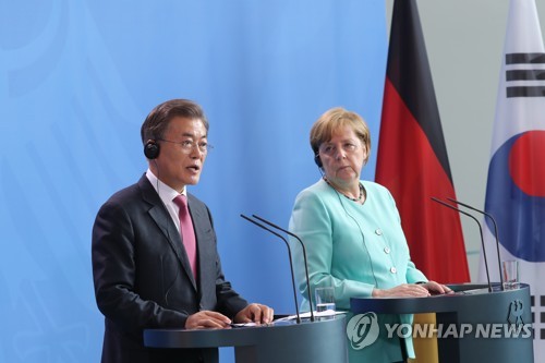 South Korean President Moon Jae-in (L) and German Chancellor Angela Merkel hold a joint press conference shortly before the start of their bilateral summit in Berlin on July 5, 2017. (Yonhap)