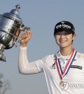 In this Associated Press photo, Park Sung-hyun of South Korea holds up the winner's trophy after capturing the U.S. Women's Open at Trump National Golf Club in Bedminster, New Jersey, on July 16, 2017. (Yonhap)