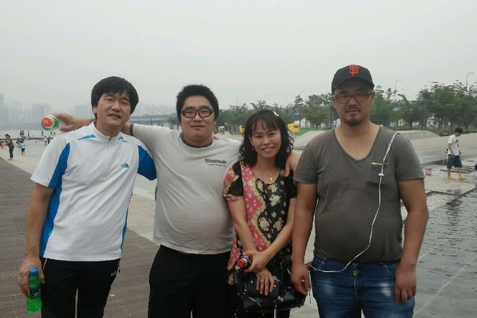 Phillip Clay, right, in a park on the Han River in Seoul, with a female social worker, a fellow deported adoptee and Song Pil-heung, left, who worked at the emergency home where Mr. Clay lived in 2014. Credit Song Pil-heung