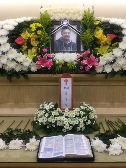 The funeral altar bearing Mr. Clay’s photo. He was 42 when he ended his life in May by jumping from the 14th floor of an apartment building. Credit Simone Huits