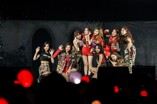 This photo provided by JYP Entertainment shows girl group TWICE waving to fans on stage during a two-day meet-and-greet event marking its two-year debut anniversary at Kyunghee University in Seoul held Oct. 14-15. (Yonhap)