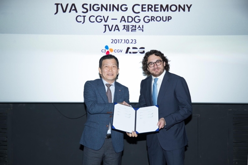 In this photo provided by CJ CGV, Seo Jung (L), chief executive officer of the South Korean company, and Grigoriy Pecherskiy, managing partner of Russia's ADG Group, pose for a photo after signing a contract on the establishment of a joint venture company in Seoul on Oct. 23, 2017. (Yonhap)