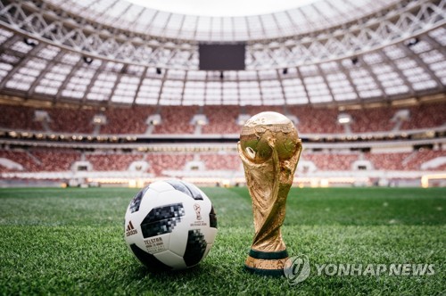 This photo, provided by Adidas, shows Telstar 18, the official match ball of the 2018 FIFA World Cup in Russia, and the FIFA World Cup trophy. (Yonhap)