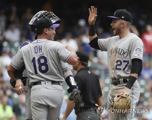 In this Associated Press photo, Oh Seung-hwan of the Colorado Rockies (L) celebrates his save with shortstop Trevor Story after beating the Milwaukee Brewers 5-4 in a Major League Baseball regular season game at Miller Park in Milwaukee on Aug. 5, 2018. It was Oh's first save for the Rockies since arriving in a trade from the Toronto Blue Jays on July 26, 2018. (Yonhap)