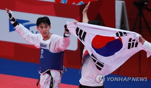 South Korea's Kim Tae-hun celebrates his gold medal in the men's 58-kilogram division taekwondo sparring competition at the 18th Asian Games at Jakarta Convention Center Plenary Hall in Jakarta on Aug. 20, 2018. (Yonhap)