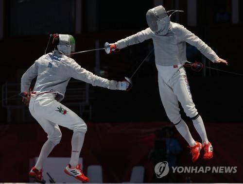 South Korean sabre fencer Gu Bon-gil (R) mounts an attack against his Iranian opponent during the men's team final at the 18th Asian Games at Jakarta Convention Center (JCC) Cendrawasih Hall in Jakarta on Aug. 23, 2018. (Yonhap)