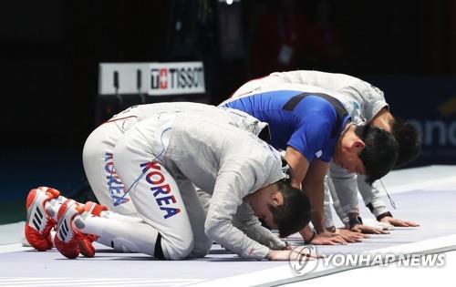 Members of the South Korean men's sabre fencing team take a bow to the crowd after winning gold medal at the 18th Asian Games at Jakarta Convention Center (JCC) Cendrawasih Hall in Jakarta on Aug. 23, 2018. (Yonhap)