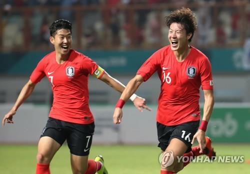South Korea's Hwang Ui-jo (R) celebrates his goal with Son Heung-min during the men's football round of 16 match against Iran at the 18th Asian Games at Wibawa Mutkit Stadium in Chikarang, Indonesia, on Aug. 23, 2018. (Yonhap)
