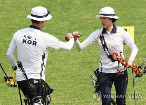 South Korean compound archers Kim Jong-ho (L) and So Chae-won bump fists during the mixed team final against Chinese Taipei at the 18th Asian Games at GBK Archery Field in Jakarta on Aug. 27, 2018. (Yonhap)