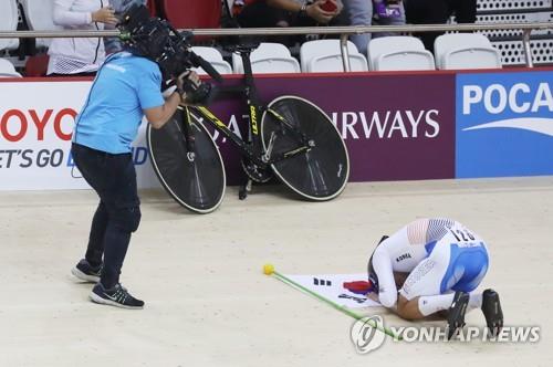 South Korean track cyclist Park Sang-hoon takes a kneeling bow to his bicycle after winning gold in the men's individual pursuit race at the 18th Asian Games at Jakarta International Velodrome in Jakarta on Aug. 29, 2018. (Yonhap)