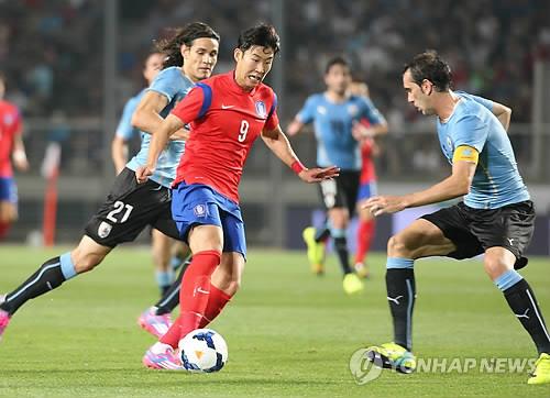This file photo taken Sept. 8, 2014, shows South Korea's Son Heung-min (C) dribbling against Uruguay's Diego Godin (R) and Edinson Cavani during a friendly football match between South Korea and Uruguay at Goyang Stadium in Goyang, north of Seoul. (Yonhap)