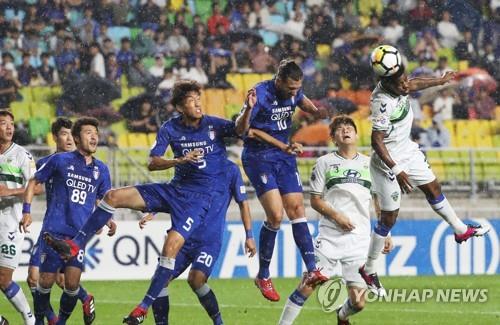 Jeonbuk Hyundai Motors' Carlos Adriano (R) heads the ball during the second leg of the Asian Football Confederation (AFC) Champions League quarterfinal match between Jeonbuk and Suwon Samsung Bluewings at Suwon World Cup Stadium in Suwon, Gyeonggi Province, on Sept. 19, 2018. (Yonhap)