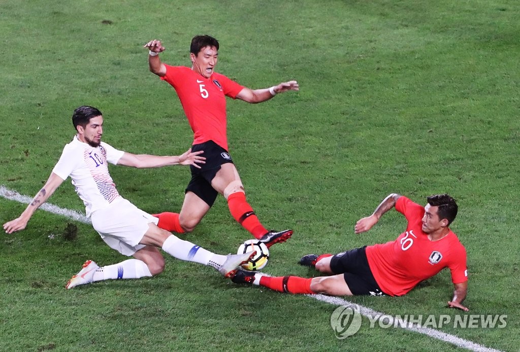 Jung Woo-young (C) and Jang Hyun-soo of South Korea (R) battle Diego Valdes of Chile for the ball during their friendly football match at Suwon World Cup Stadium in Suwon, 45 kilometers south of Seoul, on Sept. 11, 2018. (Yonhap)