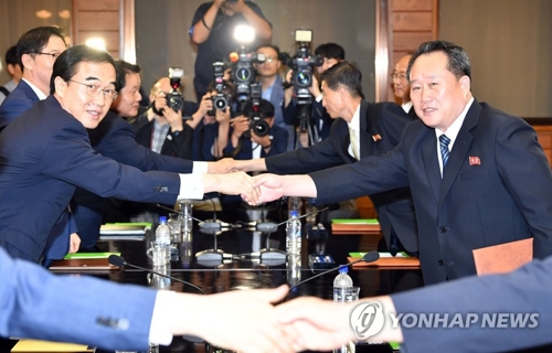South Korean Unification Minister Cho Myoung-gyon (L) shakes hands with Ri Son-gwon, a senior North Korean official, in their talks at Panmunjom on Aug. 13, 2018. (Joint press corps-Yonhap)