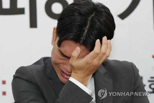 Lee Seok-cheol, the 18-year-old leader of teenage K-pop band The East Light, wipes his eyes during a press conference on Oct. 19, 2018. (Yonhap)