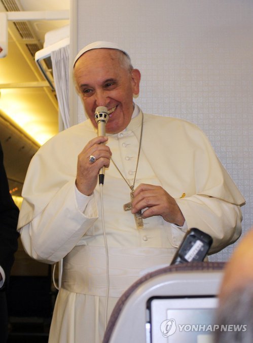 Pope Francis smiles during a press conference aboard a chartered plane after his visit to South Korea on Aug. 19, 2014. (Yonhap)