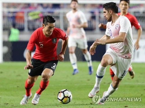 This file photo taken on Sept. 11, 2018, shows South Korean right back Lee Yong (L) dribbling against a Chile player during a friendly football match in Suwon, south of Seoul. (Yonhap)
