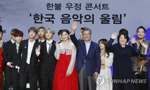 South Korean President Moon Jae-in (fourth from left) waves to a French audience in a cultural event held in Paris on Oct. 14, 2018 to mark his state visit to France. The special event included performances by famous South Korean boy group BTS. (Yonhap)