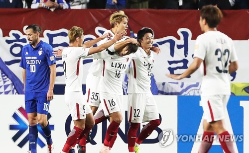 Kashima Antlers players celebrate a goal as Suwon Samsung Bluewings forward Dejan Damjanovic (L) reacts during the second leg of their Asian Football Confederation Champions League (ACL) semifinal match at Suwon World Cup Stadium in Suwon, south of Seoul, on Oct. 24, 2018. (Yonhap)
