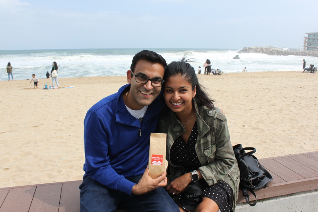 Neil Vasdev and his wife, Smita Jabob, pose for a photo with a bag of roasted coffee beans they purchased at a cafe along Anmok Beach in Gangneung, Gangwon Province. (Yonhap)