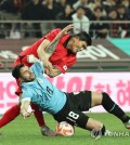 Kim Min-jae of South Korea (top) gets tangled up with Maxi Gomez of Uruguay during the countries' friendly football match at Seoul World Cup Stadium in Seoul on March 28, 2023. (Yonhap)