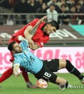 Kim Min-jae of South Korea (top) gets tangled up with Maxi Gomez of Uruguay during the countries' friendly football match at Seoul World Cup Stadium in Seoul on March 28, 2023. (Yonhap)