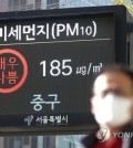 A pedestrian walks in front of an electronic display showing the fine dust level for the air in Seoul on April, 12. 2023. (Yonhap)