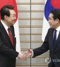 South Korean President Yoon Suk Yeol (L) and Japanese Prime Minister Fumio Kishida shake hands prior to their expanded summit talks at the latter's residence in Tokyo on March 16, 2023. Earlier in the day, Yoon began a two-day trip to Japan to put strained relations back on track. The summit marks the first time in 12 years that such talks have taken place amid tense relations between the two nations. (Yonhap)
